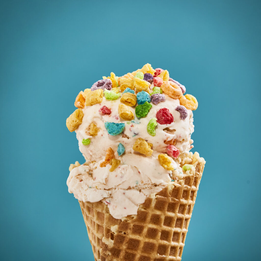 double scoop ice cream cone with cereal pieces on ice cream