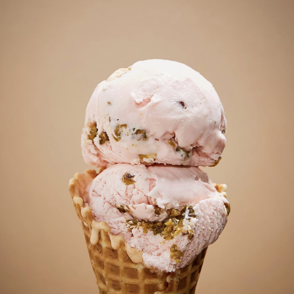 double scoop of light pink ice cream- Persian Rose on a waffle cone